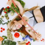 Metabolism Woman lying with fruits and vegetables holding a measuring tape symbolizing a healthy lifestyle.